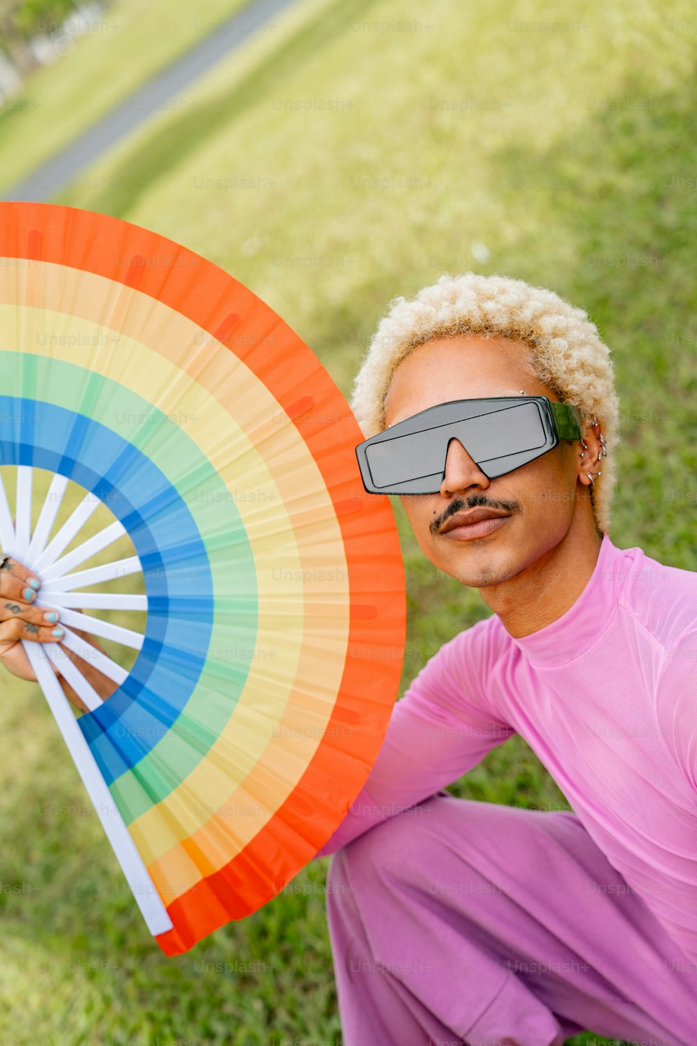 a man with a fake moustache holding a colorful umbrella