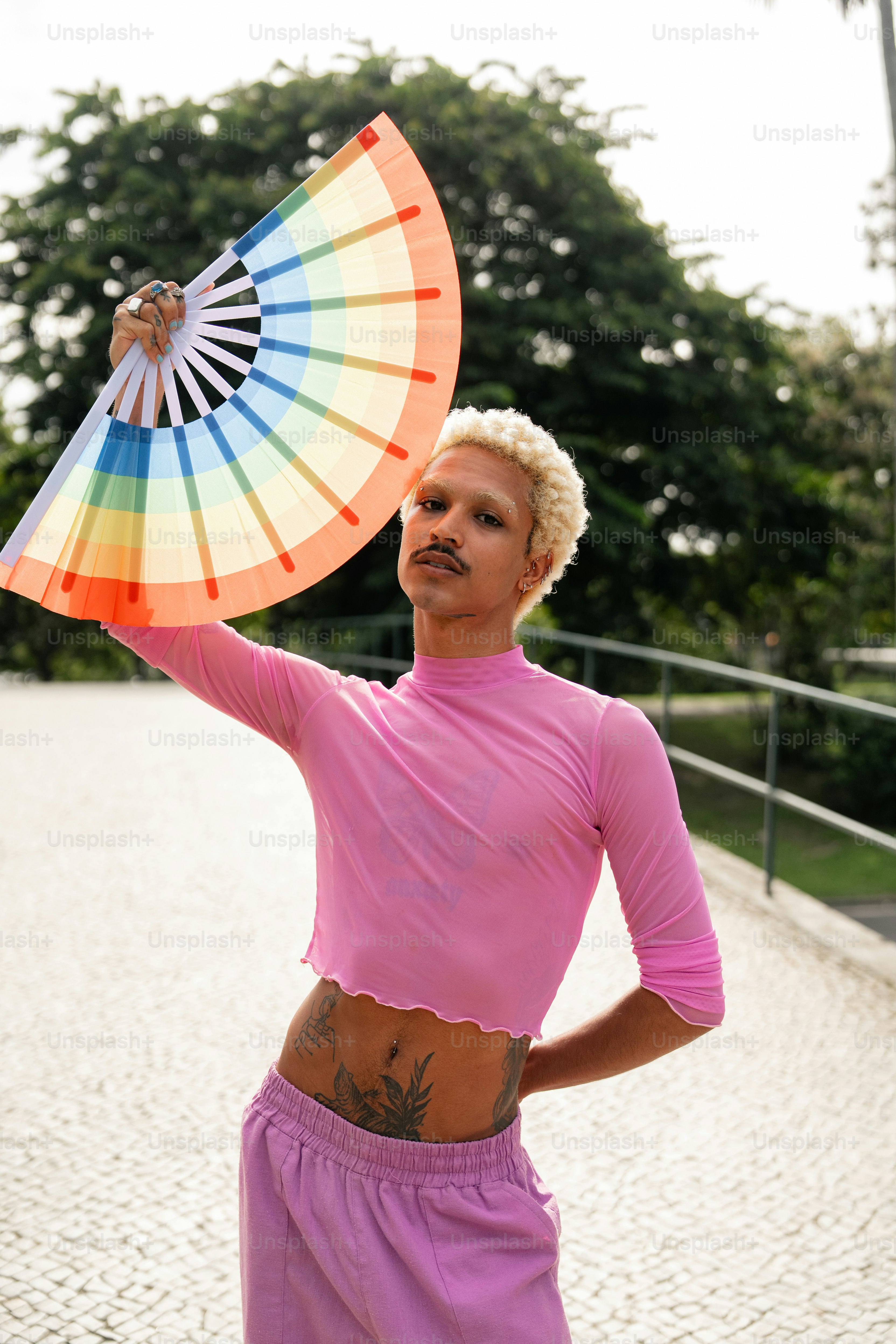 uma mulher em uma camisa rosa segurando um ventilador colorido
