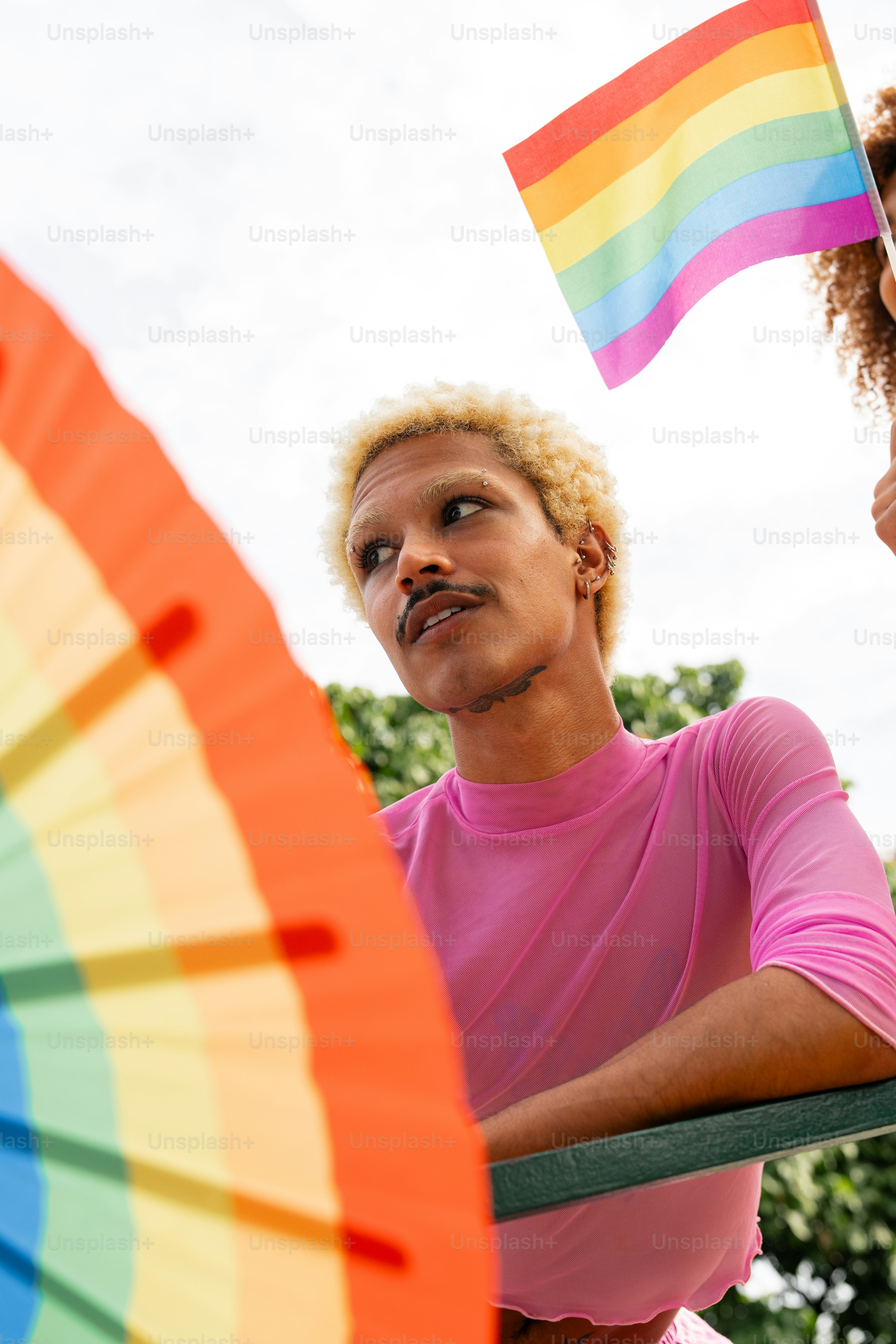 a man holding a rainbow flag next to a woman