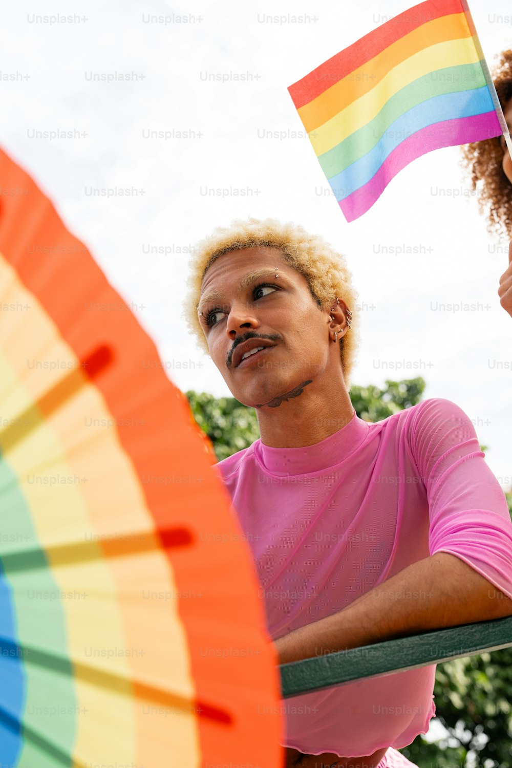 a man holding a rainbow flag next to a woman