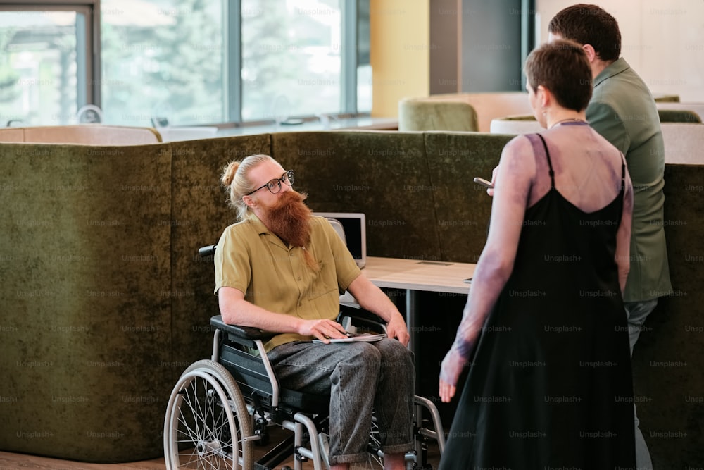 a man in a wheelchair talking to a woman