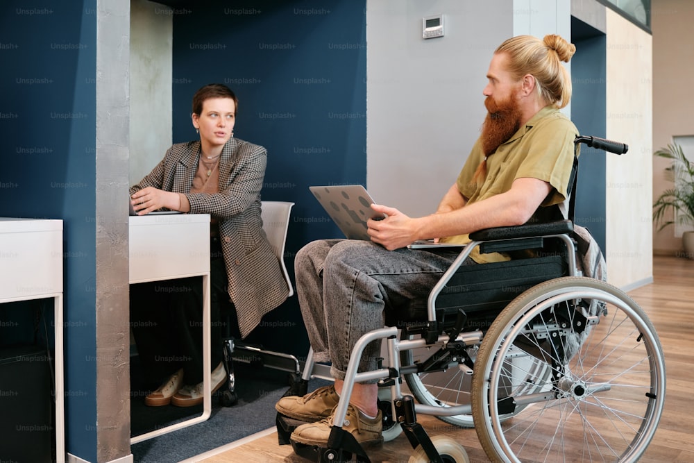 a man sitting in a wheelchair next to a woman