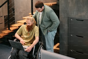 a man in a wheelchair looking at a laptop