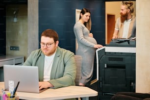 a man sitting in front of a laptop computer