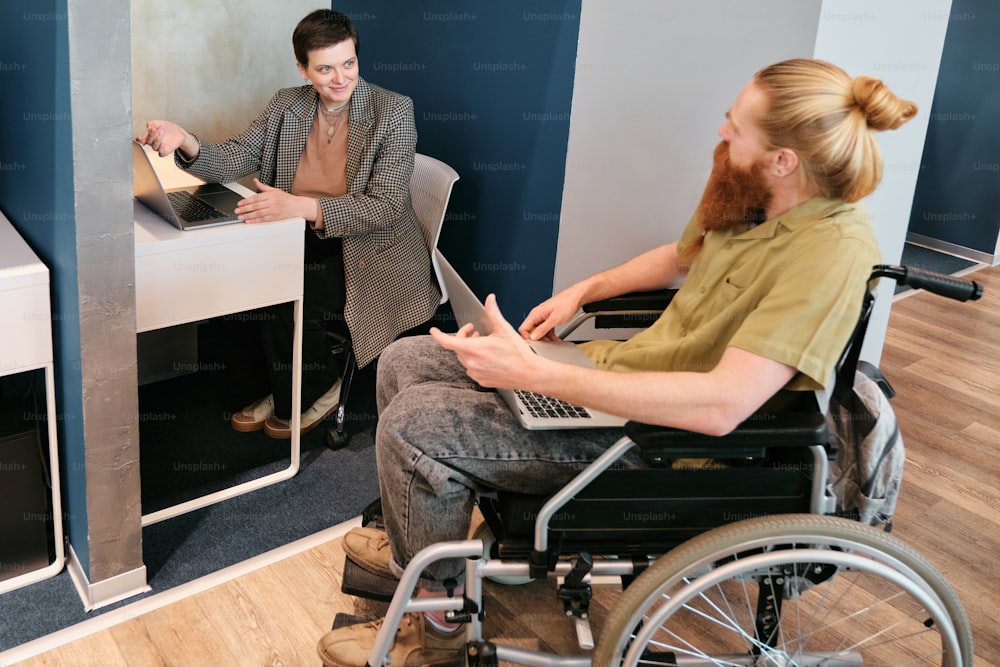 a woman sitting in a wheel chair next to a man in a wheelchair