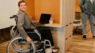 a woman in a wheel chair at a desk