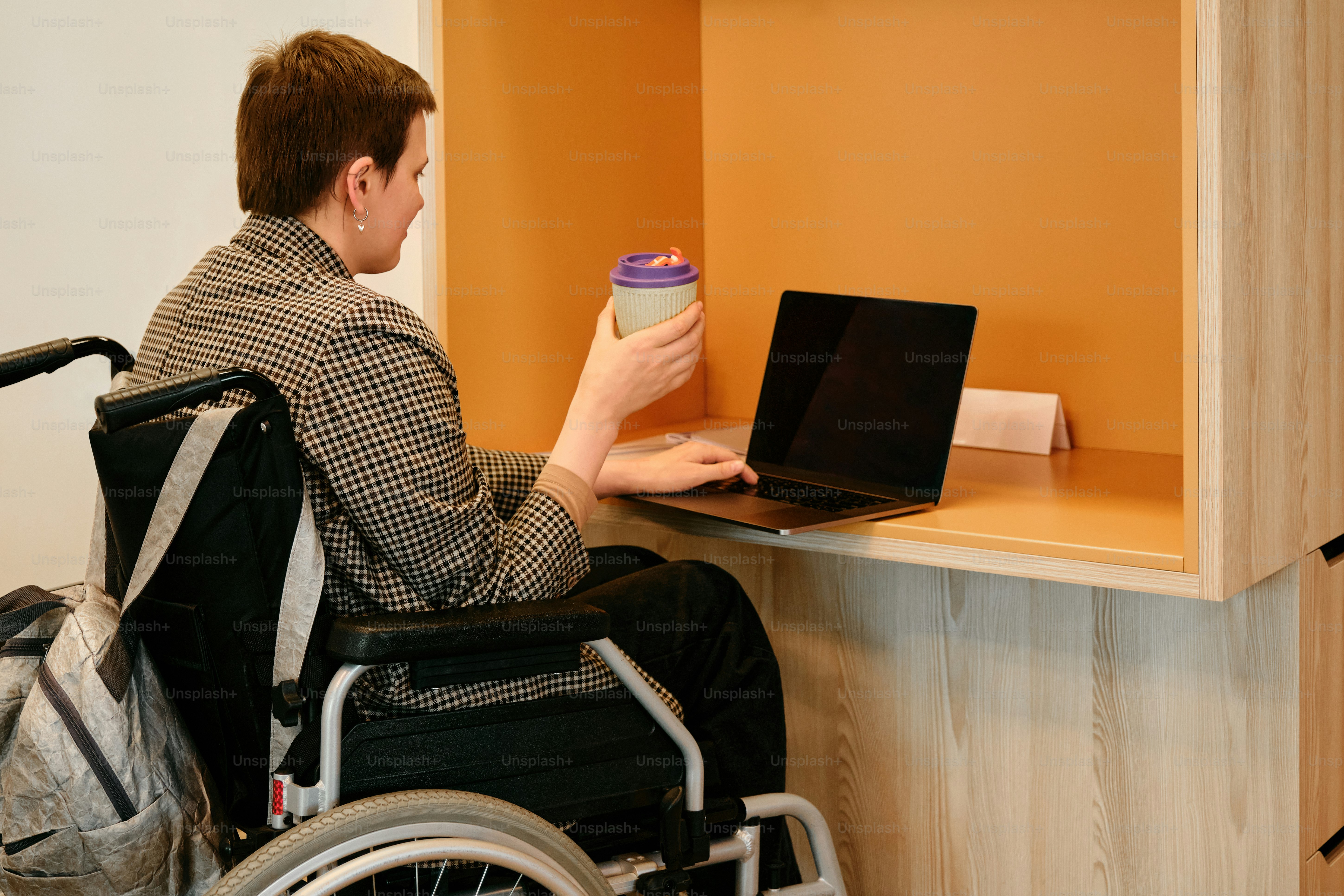 A man in a wheel chair using a laptop computer photo – Disability Image ...