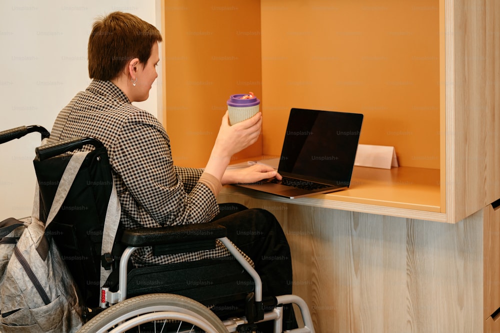 a man in a wheel chair using a laptop computer