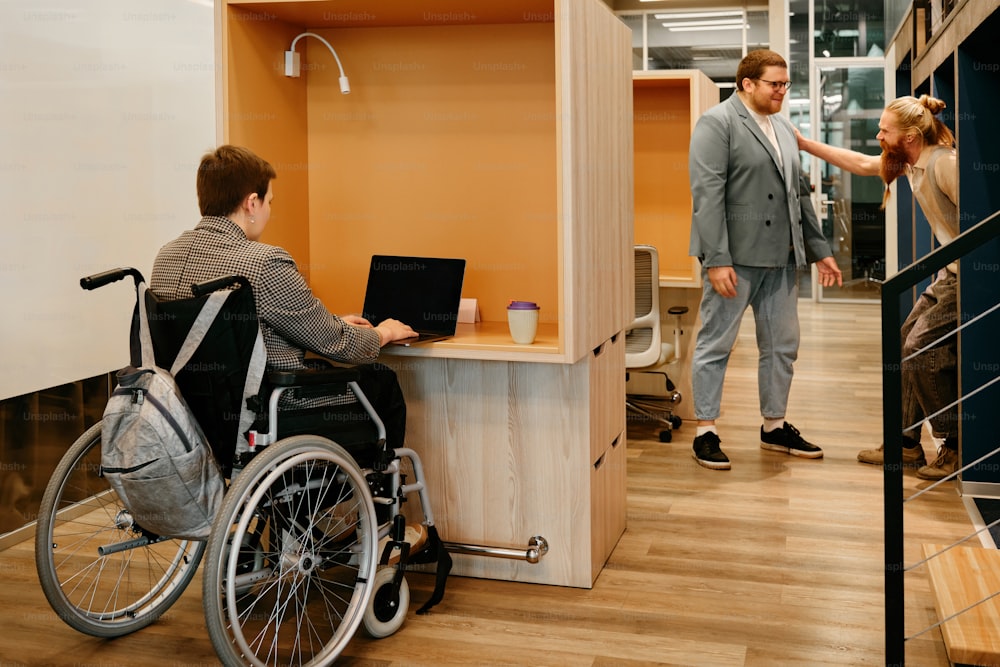 a man in a wheelchair using a laptop computer