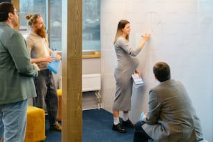 a group of people standing around a white board