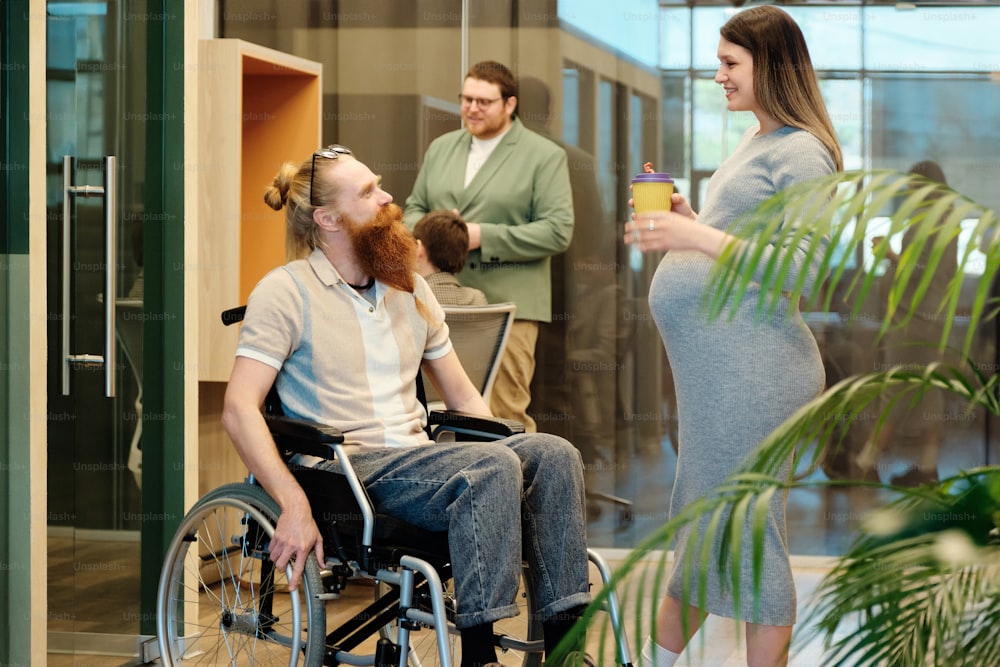 a man in a wheel chair talking to a woman in a wheelchair