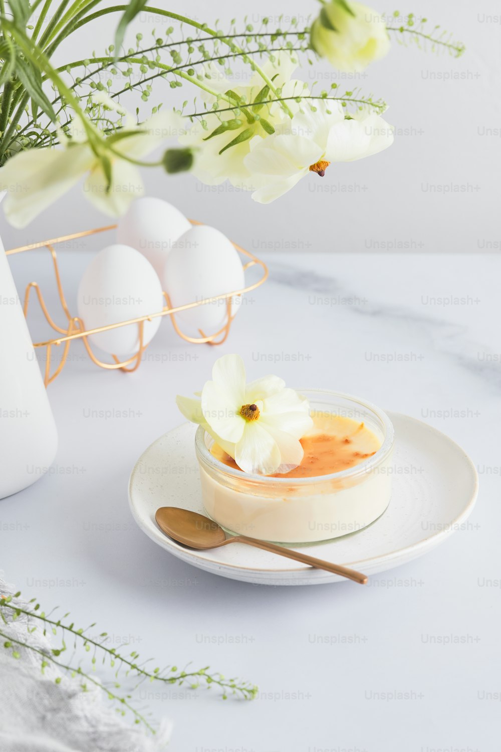 a bowl of food on a plate next to a vase of flowers