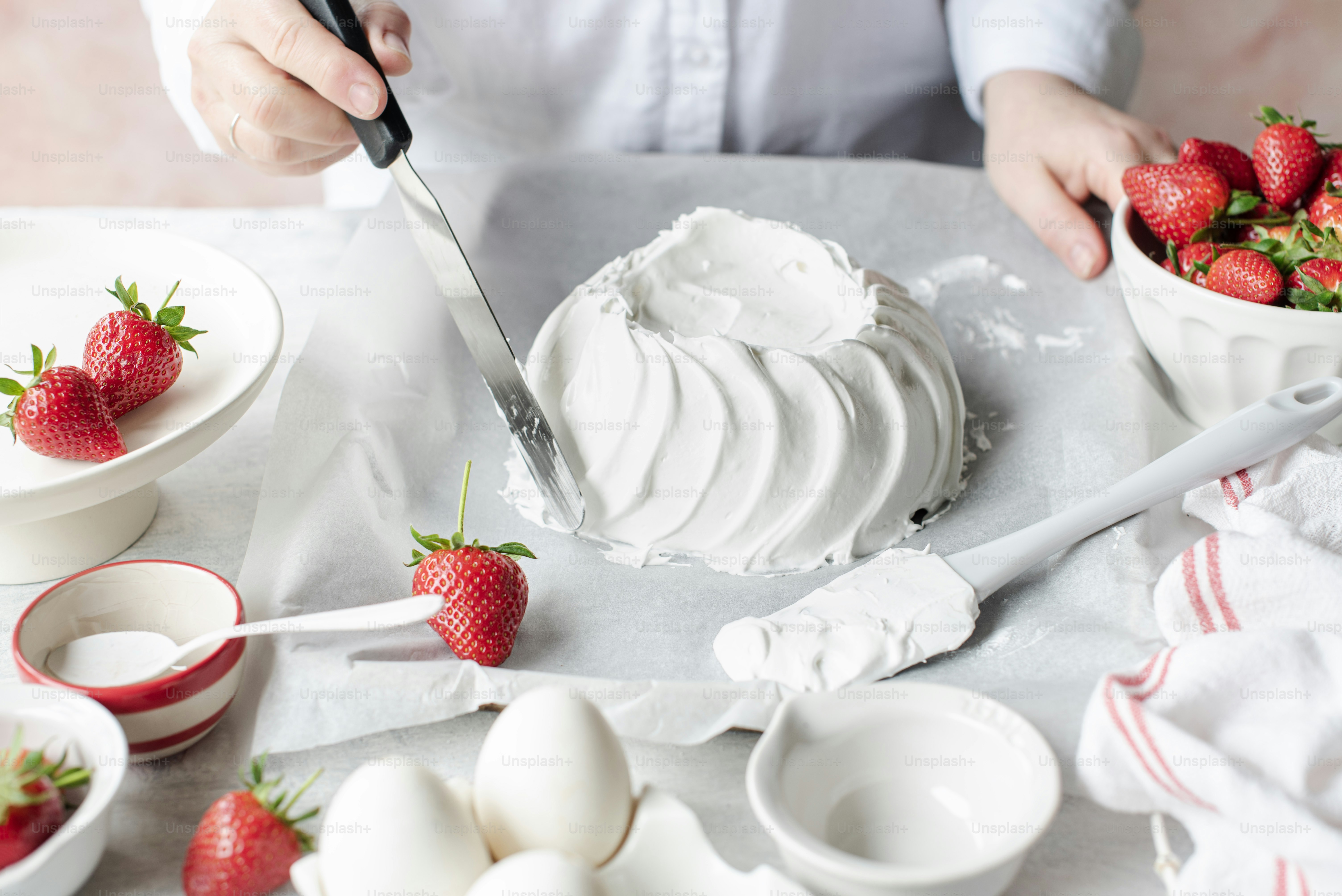 a person is cutting strawberries into small bowls