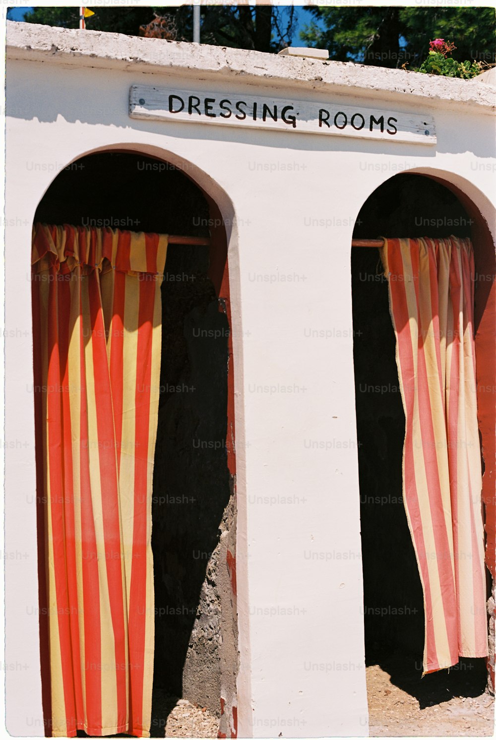 a white building with two red and yellow striped curtains
