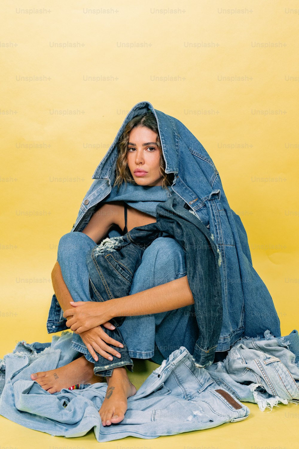 a woman sitting on top of a pile of clothes