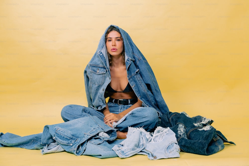 a woman sitting on a pile of clothes