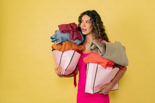 a woman holding a bag full of clothes