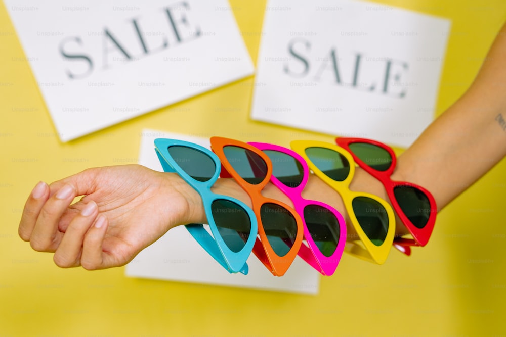 a person holding a pair of colorful sunglasses