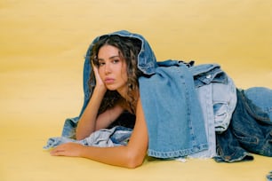 une femme allongée sur le sol avec une veste en jean sur la tête