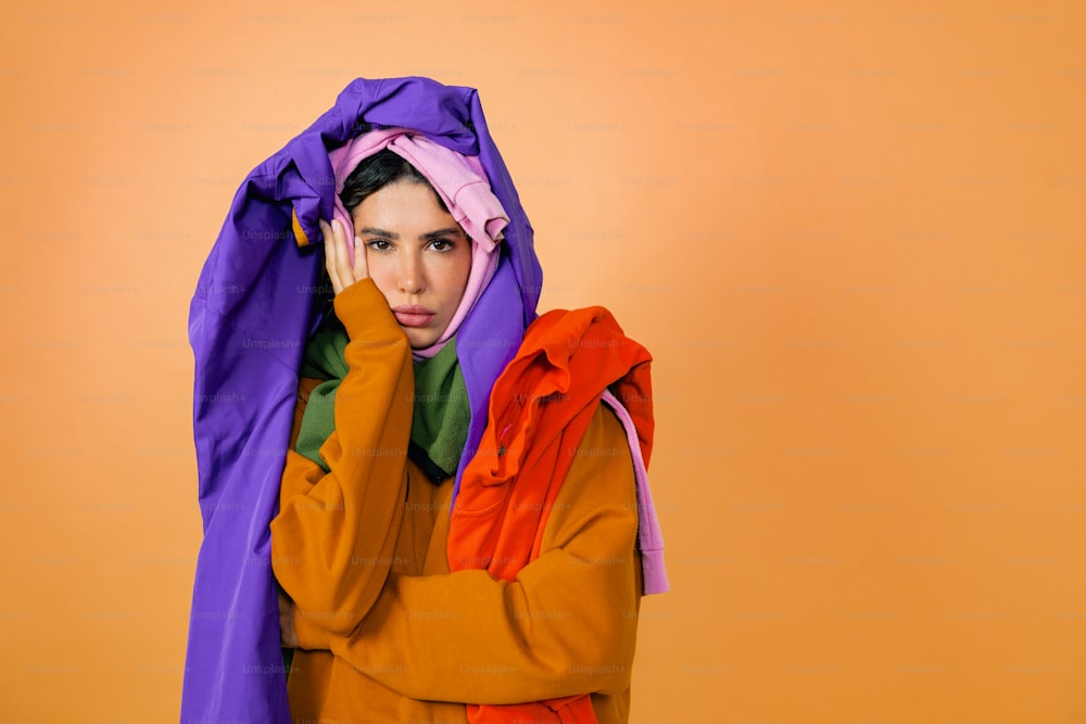 a woman in a colorful outfit covering her face