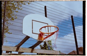 a basketball hoop in front of a fence