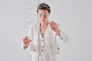 a woman is holding a wire sculpture with her hands