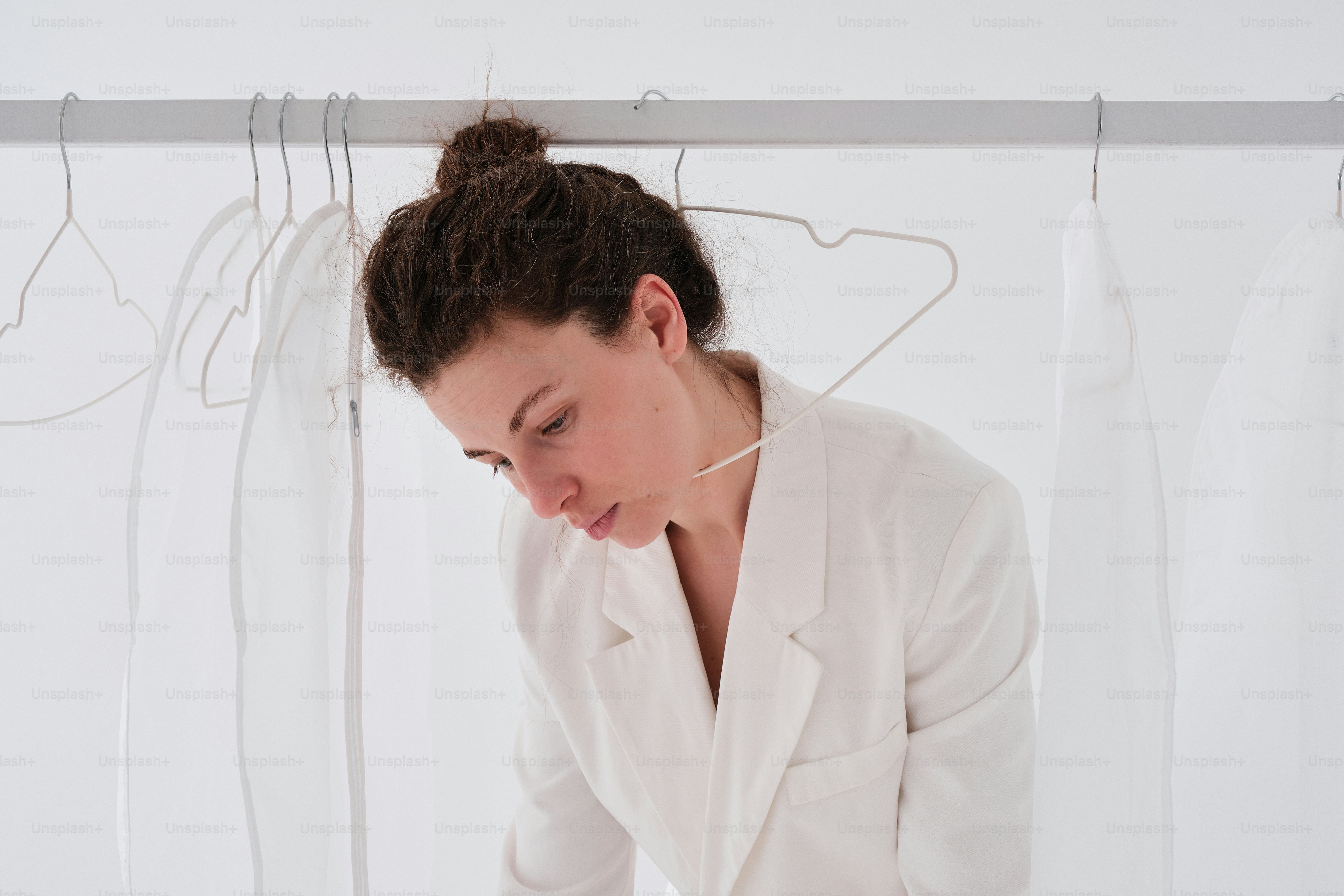 una donna in abito bianco che guarda il suo cellulare