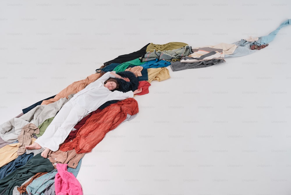 Un hombre acostado encima de una pila de ropa