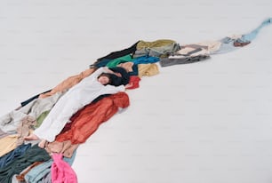 un uomo sdraiato sopra una pila di vestiti