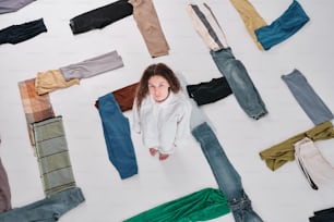 a woman standing in front of a wall of pants