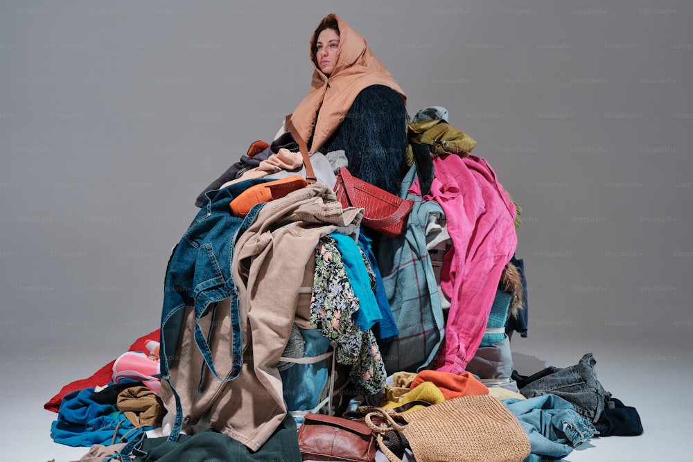 una mujer sentada encima de una pila de ropa