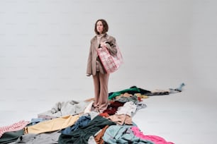 una donna in piedi sopra un mucchio di vestiti