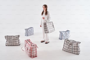 una mujer de pie frente a un montón de bolsas