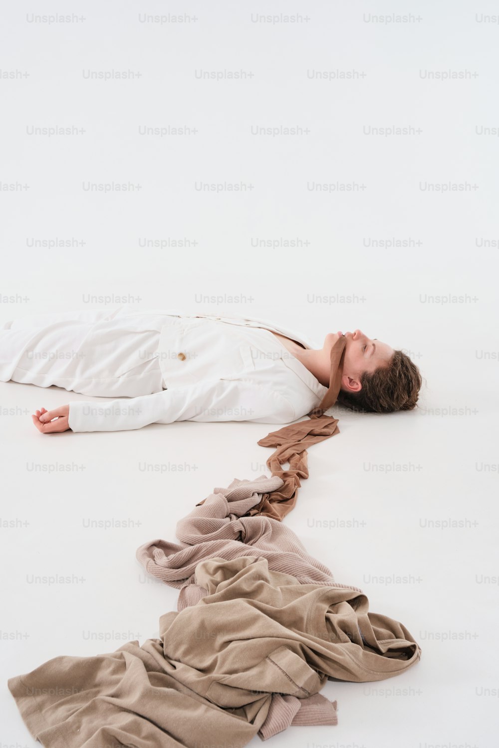 a man laying on the ground next to a pile of clothes