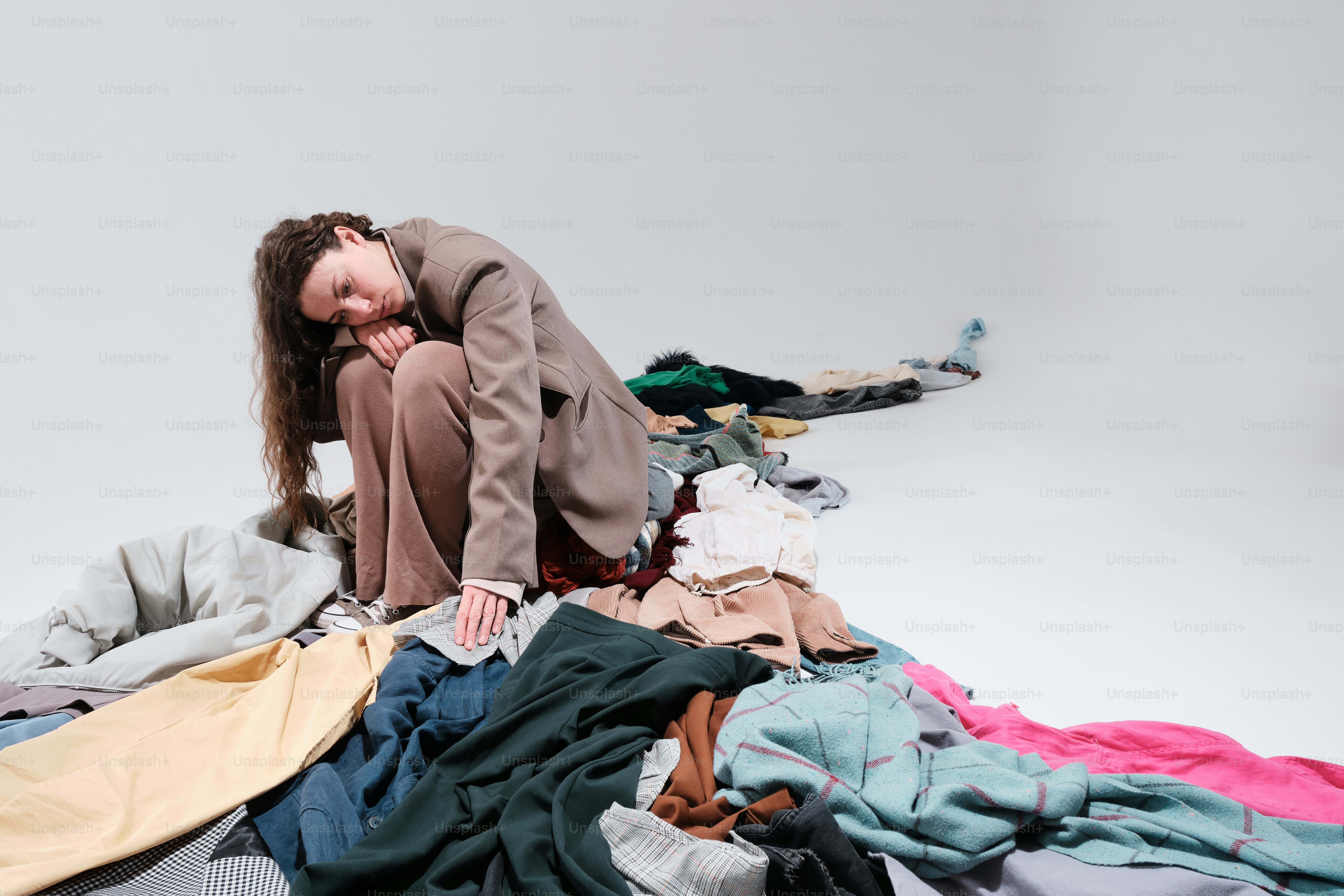 a woman sitting on a pile of clothes