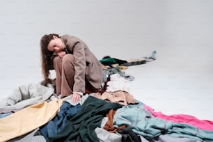 una donna seduta su un mucchio di vestiti