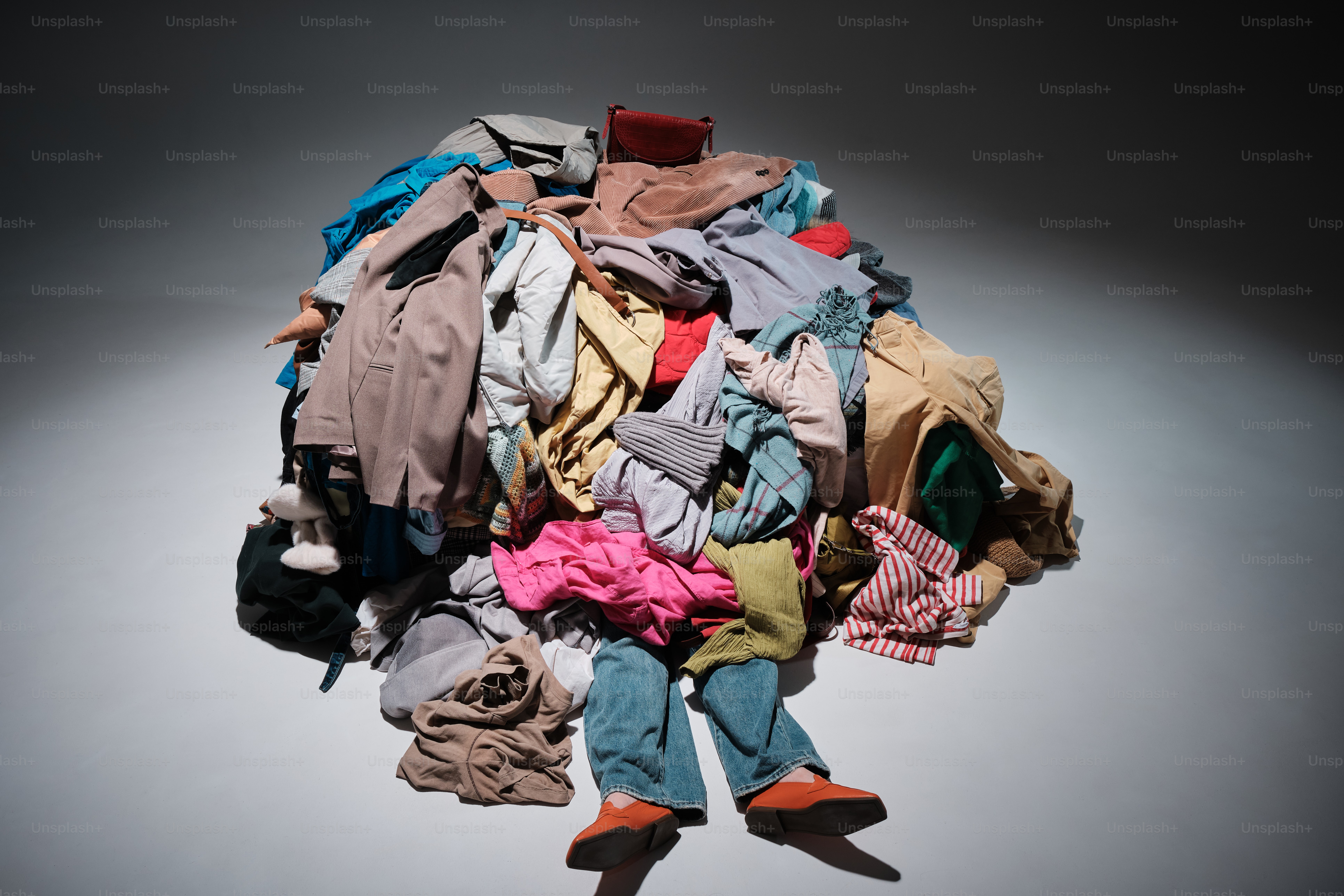 conceptual shot of model under mountains of clothing