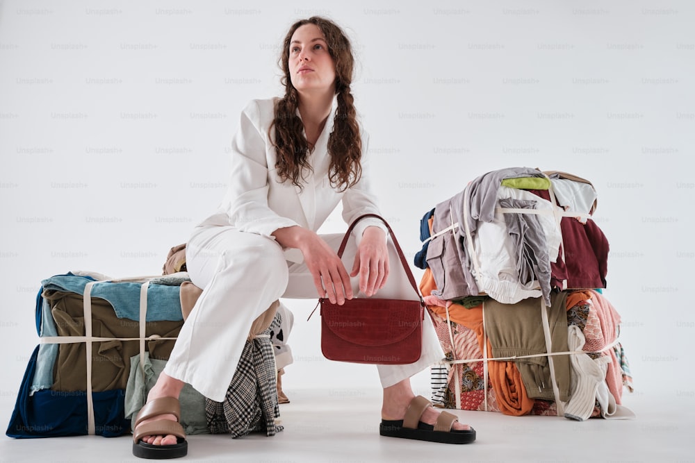 a woman sitting on a pile of luggage