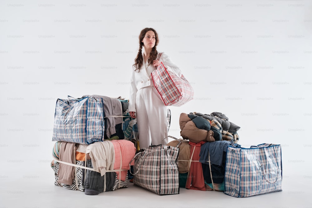 a woman standing in front of a pile of luggage