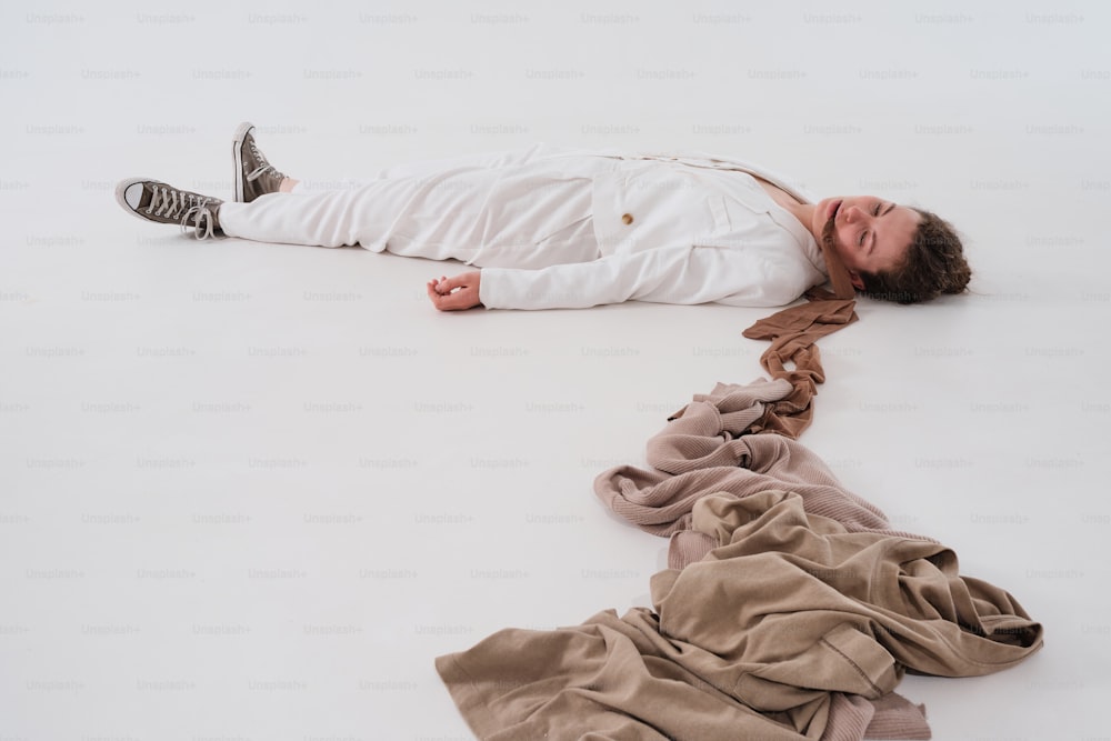 a man laying on the ground next to a pile of clothes
