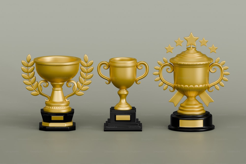 três troféus dourados com bases pretas em um fundo cinza