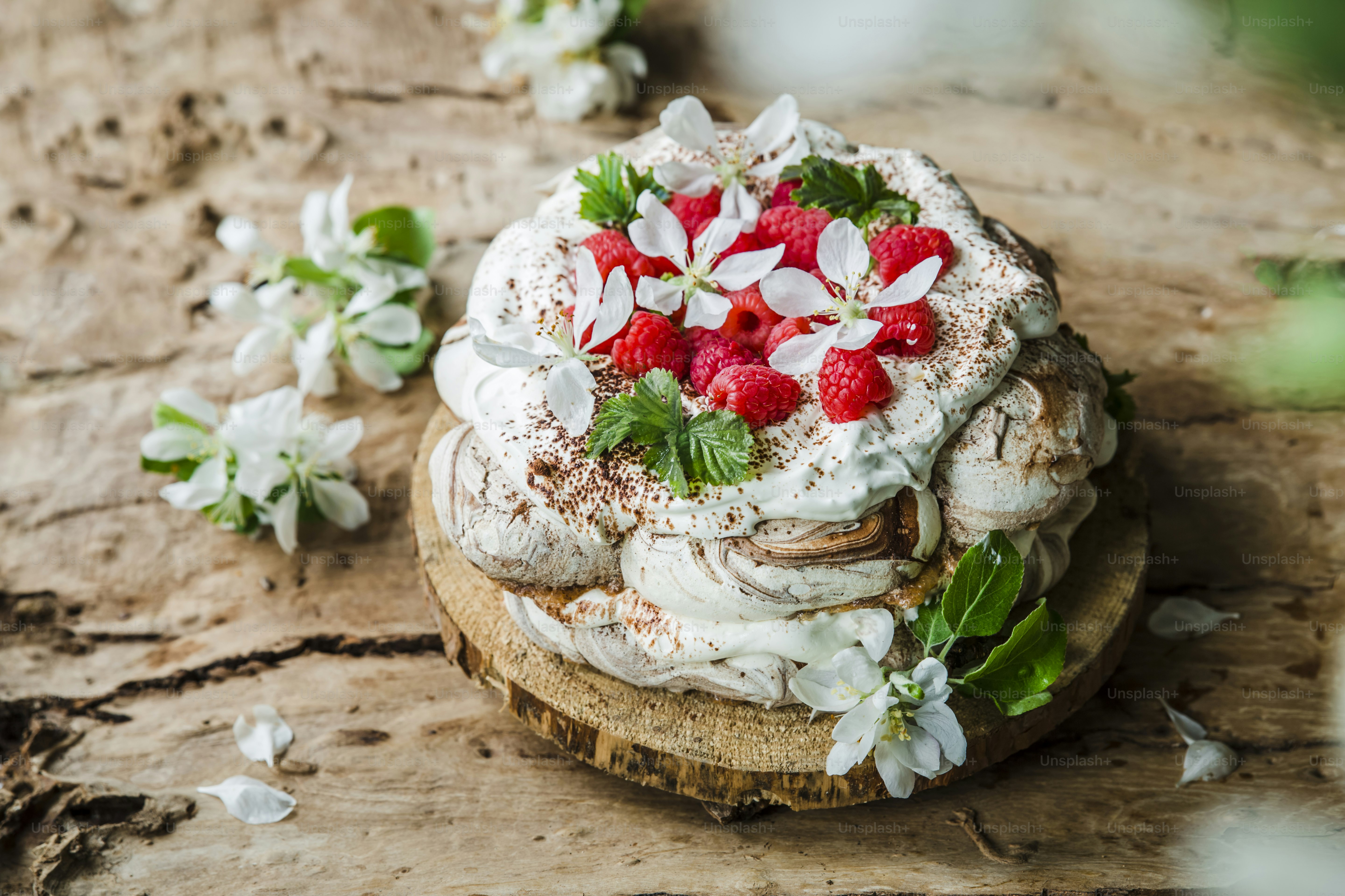 A cake with strawberries on top of a wooden table photo – Meringue ...