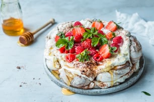 a cake covered in whipped cream and strawberries