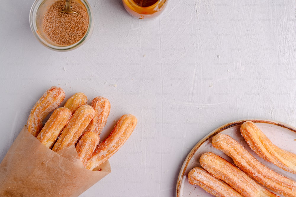 a plate of churros next to a cup of tea