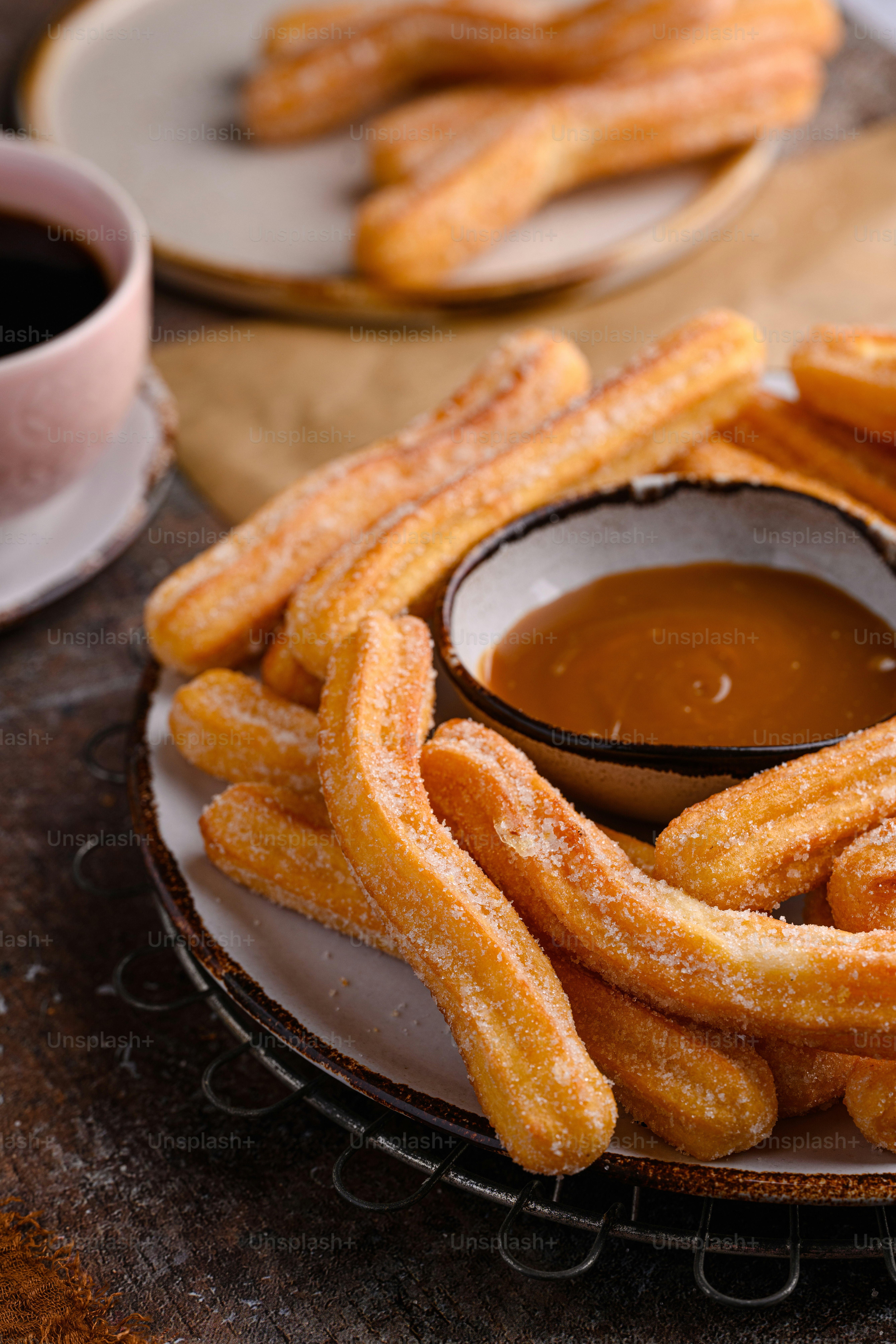 Un plato de palitos de churro con salsa para mojar