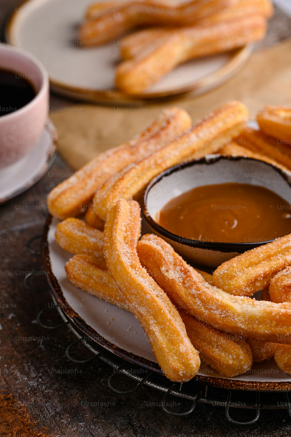 a plate of churro sticks with dipping sauce