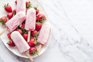 a white plate topped with popsicles and strawberries