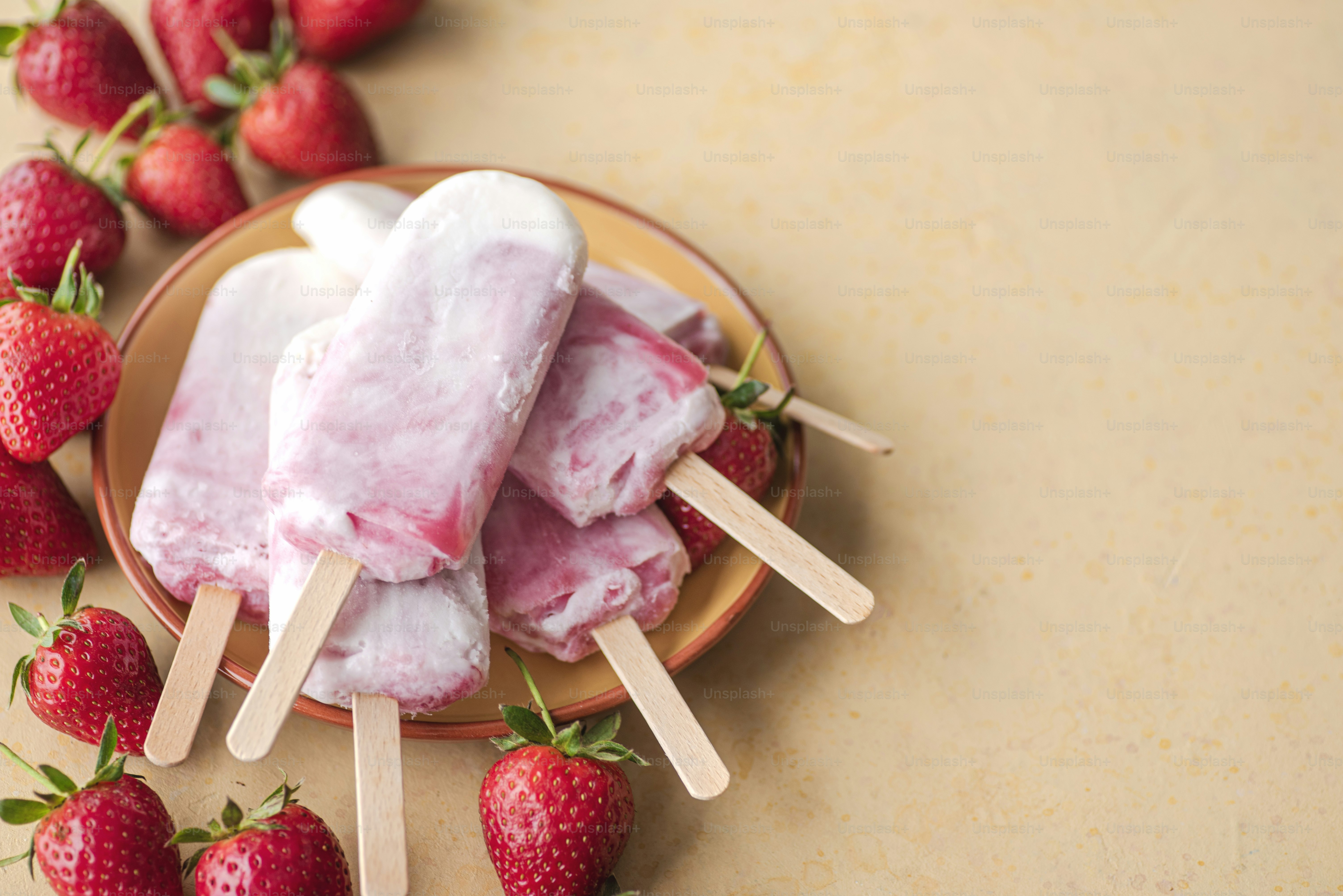 a plate topped with popsicles and strawberries