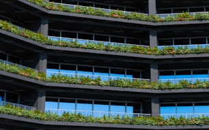 a very tall building with plants growing on the balconies