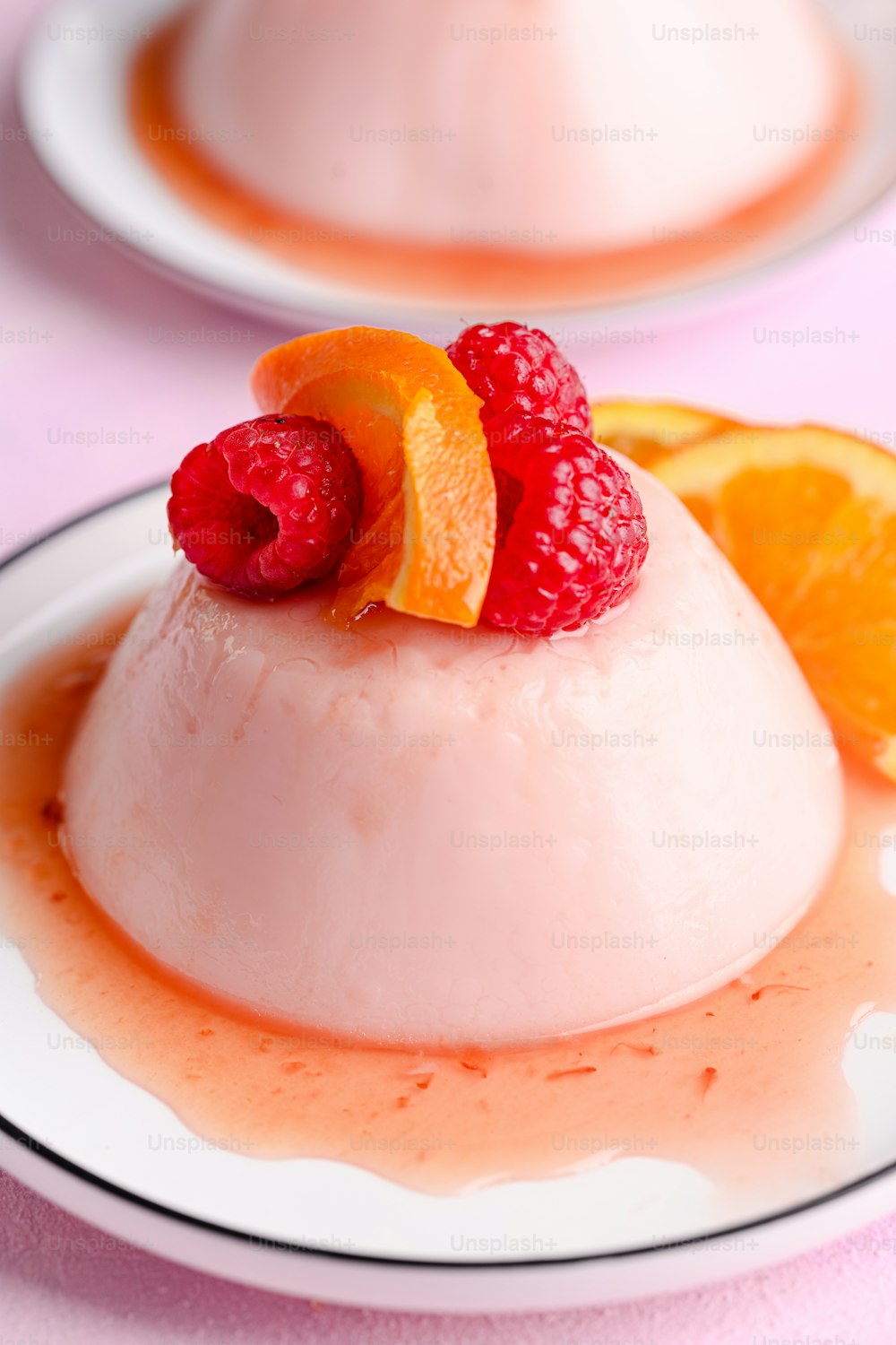 a dessert with oranges and raspberries on a plate